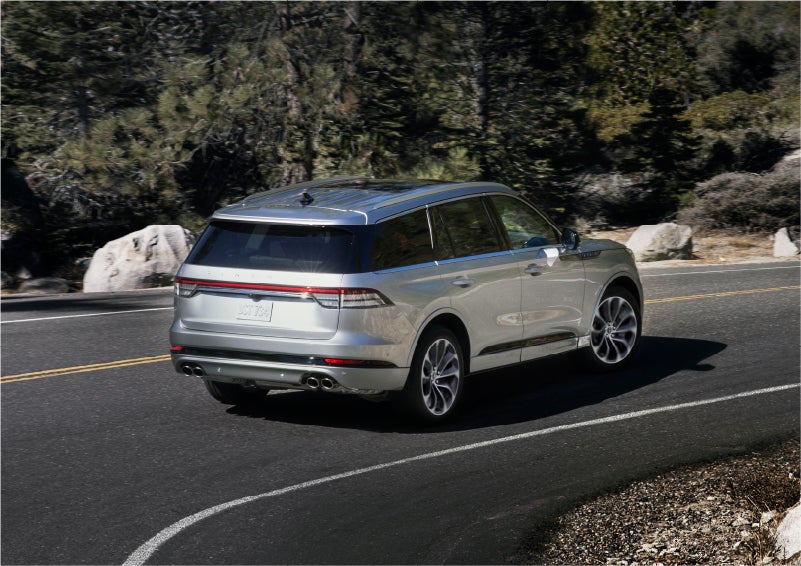 A 2023 Lincoln Aviator® Grand Touring model is shown being driven on a tight turn of a mountain road | McLarty Daniel Lincoln in Bentonville AR