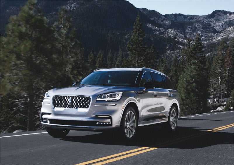 A 2023 Lincoln Aviator® Grand Touring SUV being driven on a winding road to demonstrate the capabilities of all-wheel drive | McLarty Daniel Lincoln in Bentonville AR