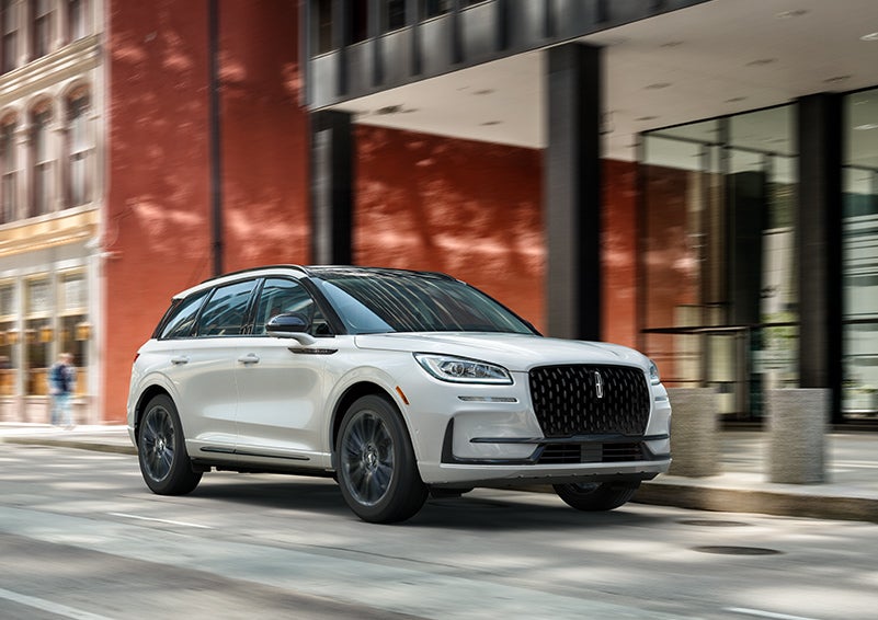 The 2024 Lincoln Corsair® SUV with the Jet Appearance Package and a Pristine White exterior is parked on a city street. | McLarty Daniel Lincoln in Bentonville AR