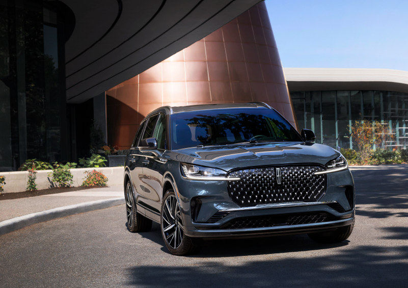 A gray 2025 Lincoln Aviator® SUV is parked outside a modern building with the sun shining. | McLarty Daniel Lincoln in Bentonville AR
