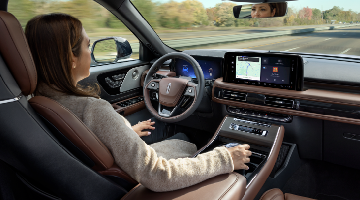 A woman is seen sitting in the driver’s seat of her 2025 Lincoln Aviator® SUV with her hands off the steering wheel. | McLarty Daniel Lincoln in Bentonville AR