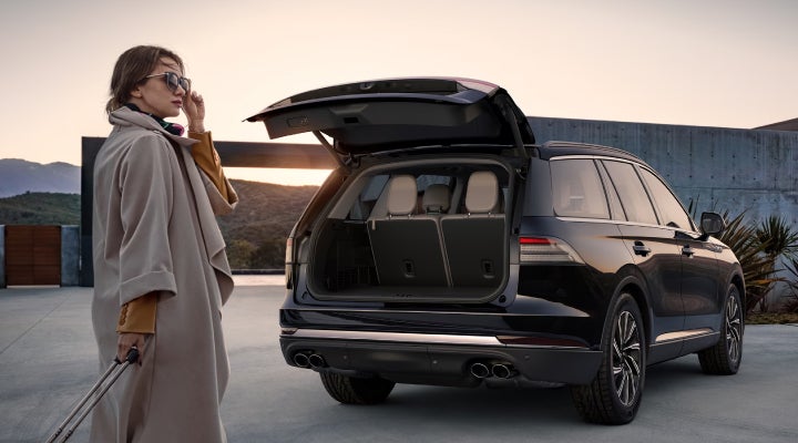A woman approaches a 2026 Lincoln Aviator® SUV with its rear liftgate open. | McLarty Daniel Lincoln in Bentonville AR