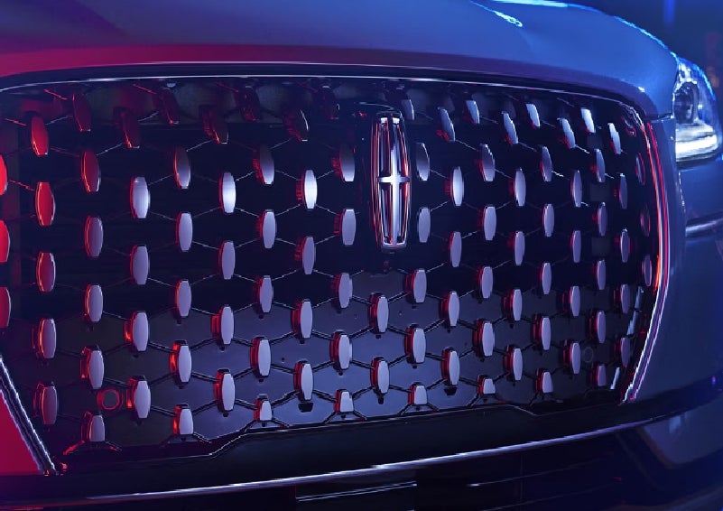 The grille of a 2025 Lincoln Corsair&reg; SUV reflects neon light at night. | McLarty Daniel Lincoln in Bentonville AR