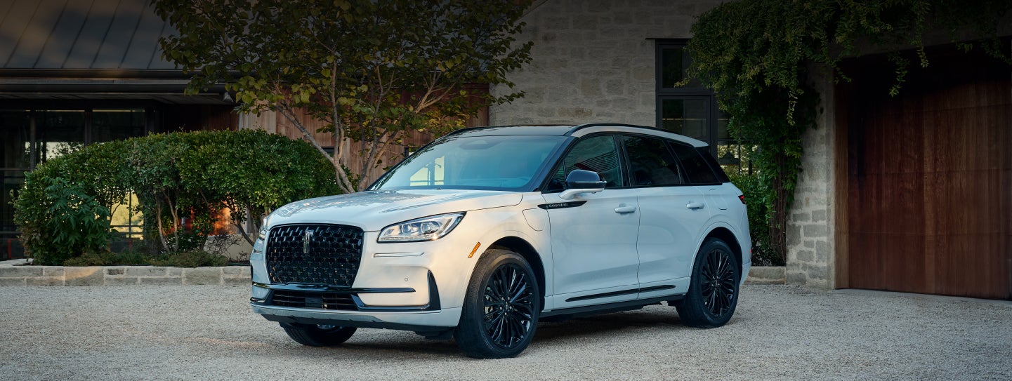 A 2026 Lincoln Corsair® SUV is parked in front off a luxury home. | McLarty Daniel Lincoln in Bentonville AR