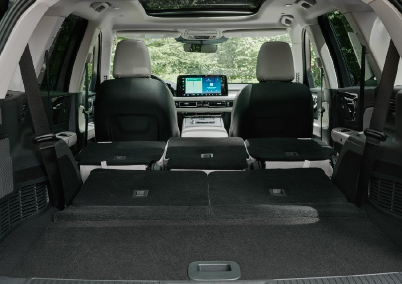 A rear to front view of the interior of a 2027 Lincoln Aviator® Black Label™ SUV shows the third and second rows folded flat | McLarty Daniel Lincoln in Bentonville AR