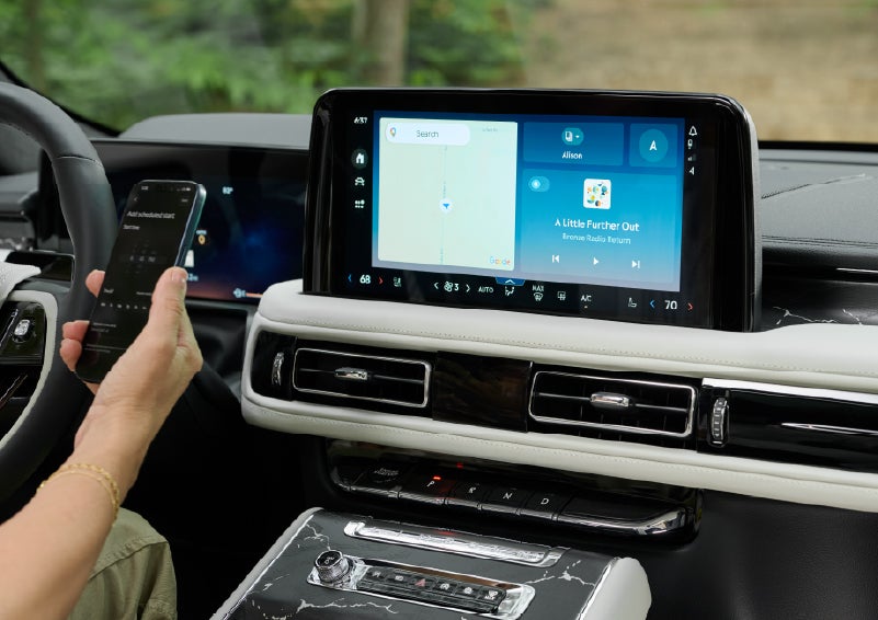 A person pairs thier phone with the center touchscreen of a 2027 Lincoln Aviator® Black Label™ SUV | McLarty Daniel Lincoln in Bentonville AR